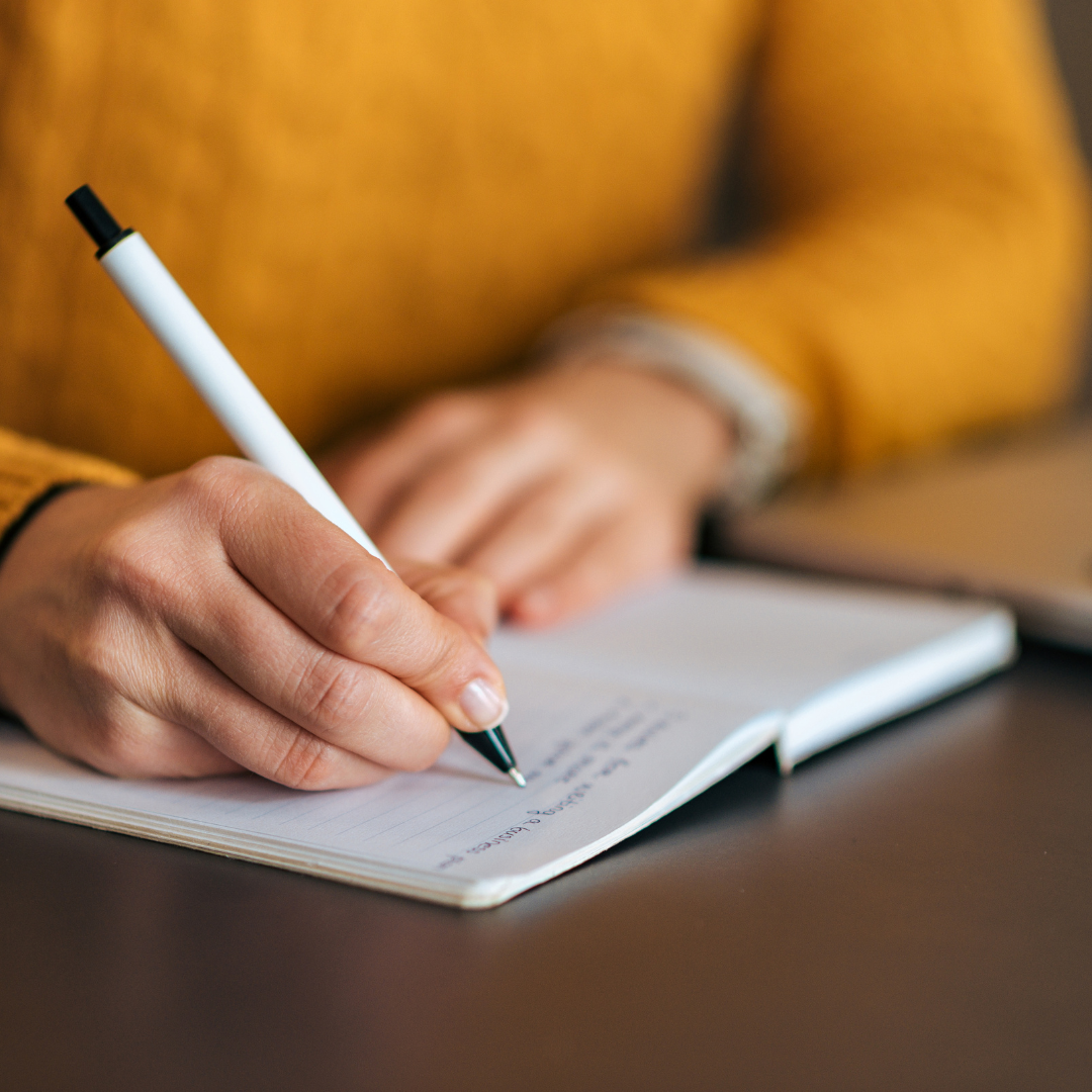 person writing in a journal